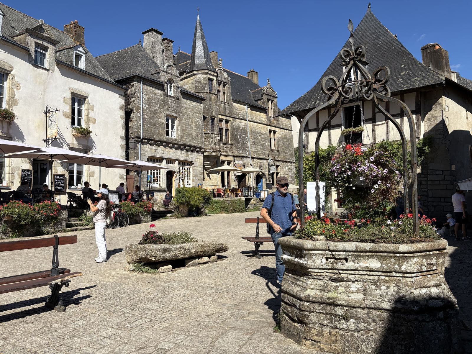 Le puits en pierre couvert d'ardoise et fleuri de pétunias, sur la place du Puits à Rochefort-en-Terre